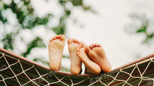 Preview: Feet of children, which swinging on hammock at summer.Kids relax,happy childhood