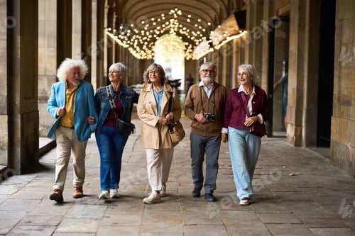 Preview: Senior friends enjoying walking tour in historic colonnade
