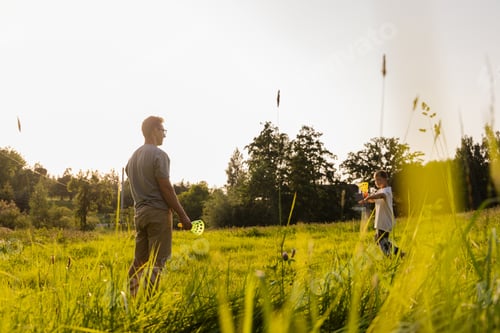 Preview: Father and son engage in a fun game together in a lush green field