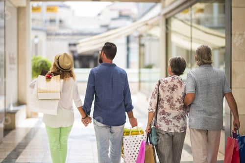 Preview: group or family walking together in a mall doing shopping and holding shopping bags