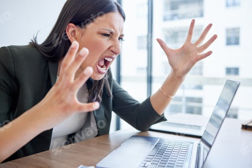 Preview: Shot of a young businesswoman yelling while using a laptop in an office at work