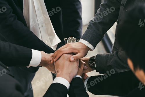 Preview: Close up of group of business people joining their hands together in unity.