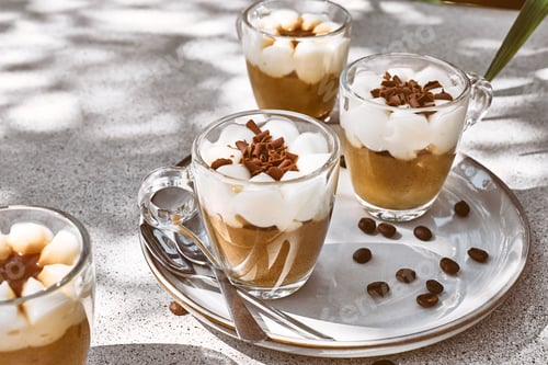 Preview: Traditional Italian dessert Tiramisu in glass cups on gray table.