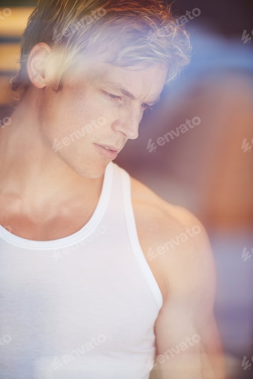 Preview: Thinking deeply. Handsome blonde man looking through a window in contemplation.