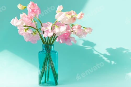 Pink Flowers in Blue Vase on Teal Background