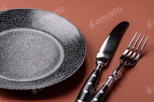 Preview: Empty round black plate for food, kitchen utensils on dining table. Empty plate