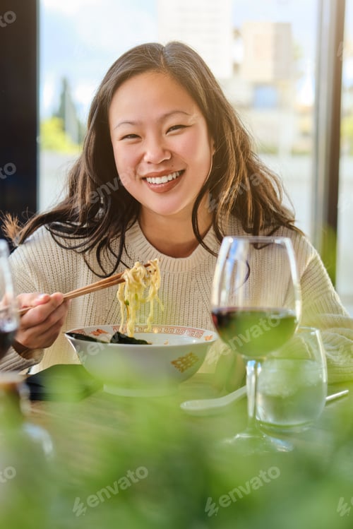Preview: Young female eating ramen in restaurant