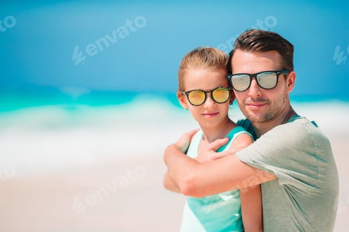 Preview: Little girl and happy dad having fun during beach vacation