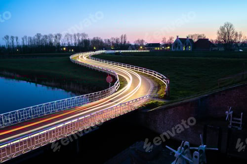 Preview: Beautiful picture of a street with car light trails next to the river at night