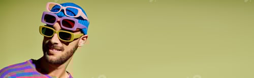 Preview: Trendsetting young man flaunts vibrant sunglasses against a fresh green backdrop