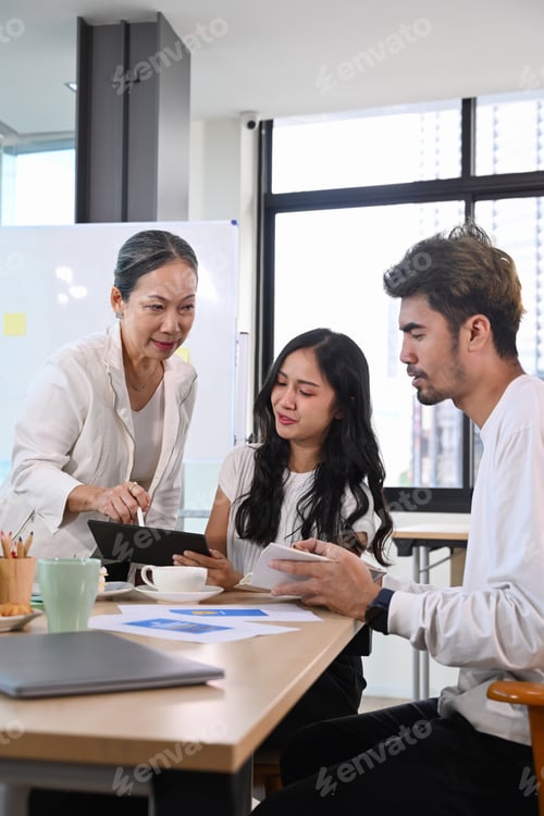 Preview: Senior older female executive ceo and young employee discuss corporate project together at briefing.