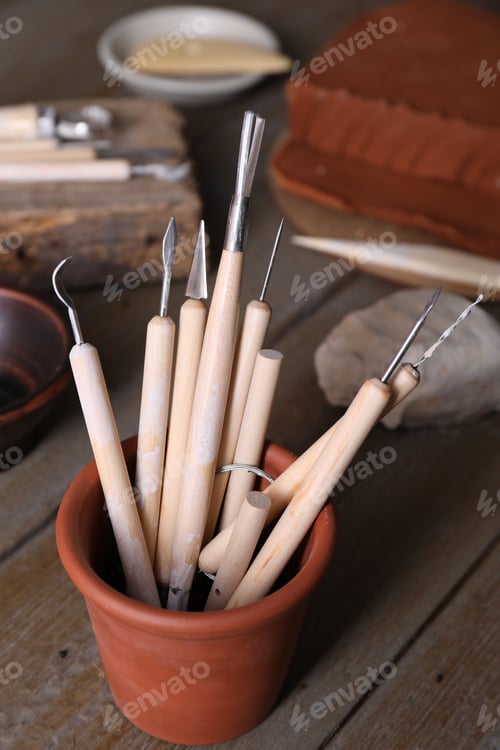 Preview: Set of different clay crafting tools on wooden table in workshop