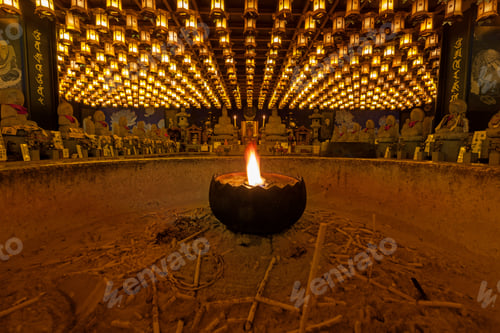 Preview: Burning candle in Burner pot with and incense sticks in japanese cave temple.