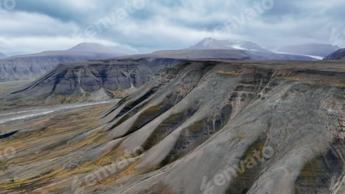 Preview: Stunning view of Svalbards rugged terrain with dramatic mountain formations and overcast skies