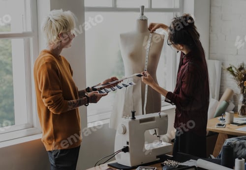 Preview: Fashion designer using a measuring tape on a mannequin