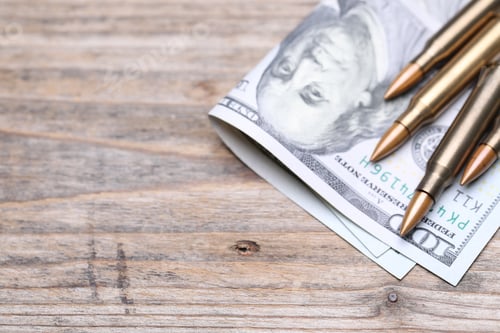 Preview: Firearm cartridges and dollars on wooden table, above view. Space for text