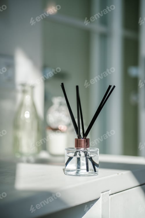 Preview: An aromatic reed diffuser stands on a table against a blurry background.