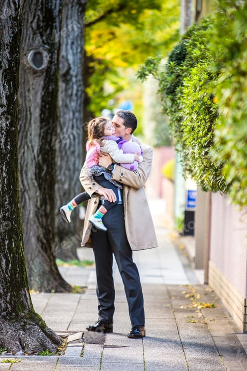 Preview: Father carrying daughter on pavement