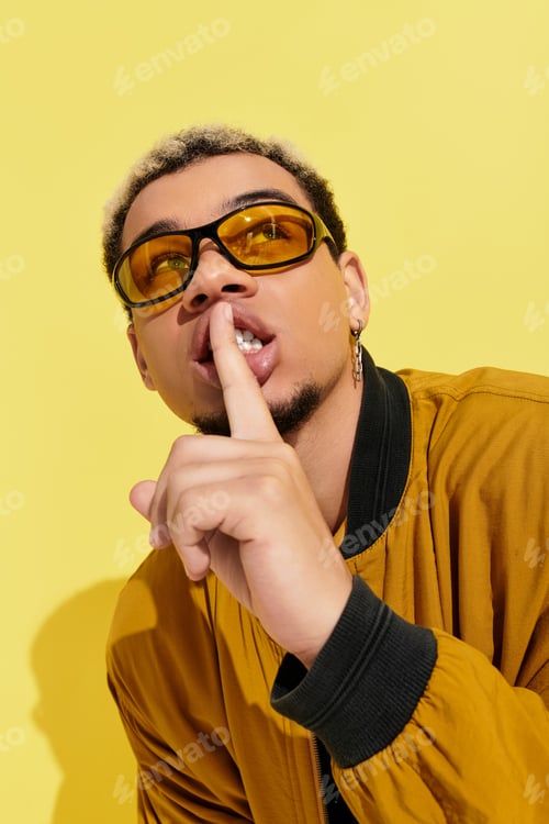 Preview: Stylish young african american man wearing bomber jacket in bright studio setting