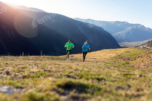 Preview: Healthy young couple running on mountain trail in the morning.