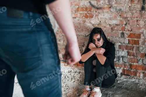 Preview: Violent man standing and threatens girl that sits on the floor with teddy bear in abandoned building