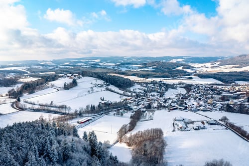 Preview: Aerial view of snowy village landscape in winter.