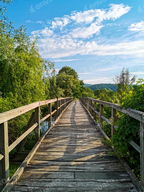 Preview: Old wooden footbridge on a sunny day in spring or summer