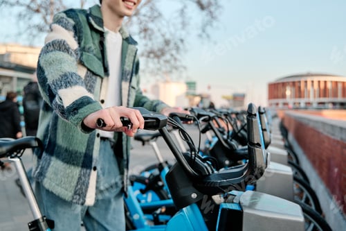 Preview: unrecognizable young man riding an electric bicycle. Sustainable and ecological transport concept.