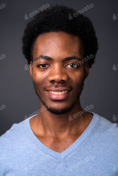 Preview: Face of young handsome African man against gray background
