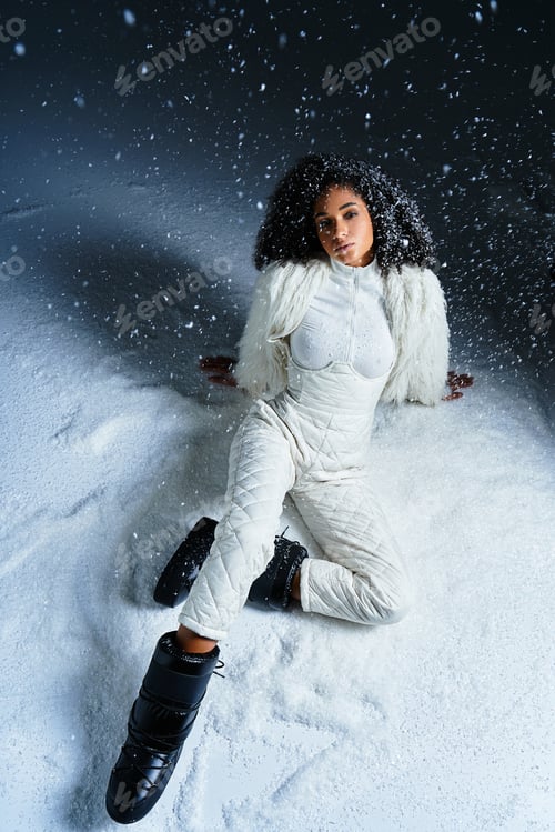 Preview: Elegant winter fashion portrait of a stunning woman in a white ski suit and faux fur jacket
