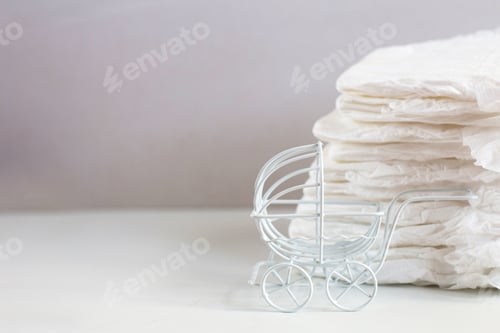 Preview: Baby diapers with a toy carriage on a white background