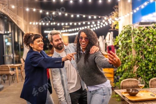 Preview: Playful friends taking selfie at night party oudoors