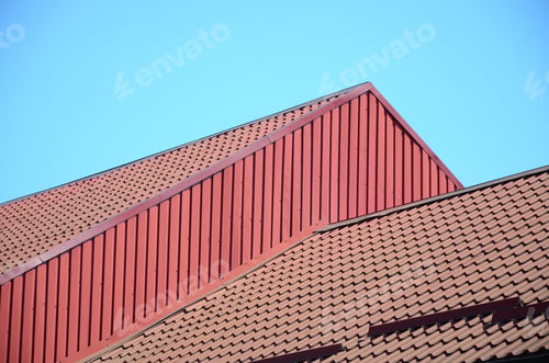 Preview: A fragment of a roof from a metal tile of dark red color. Quality Roofing