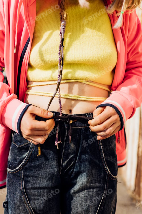 Preview: Close up of trendy nonconformist fit young woman wearing alternative cool crop top outdoors