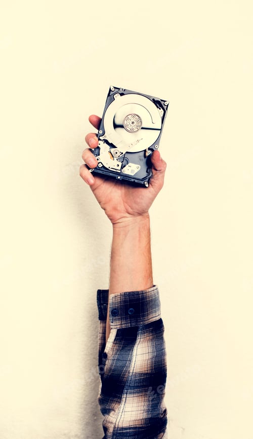 Preview: Hand holding computer hard disk drive isolated on white