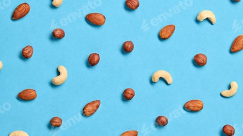 Preview: Nuts mix colorful pattern on blue background. Fitness vitamin composition. Almonds, hazelnuts, cashe