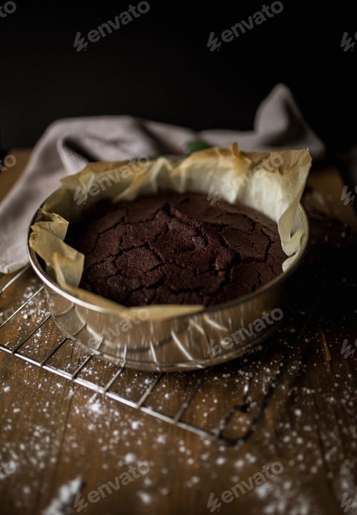 Preview: Freshly baked chocolate cake on a rustic table setting.