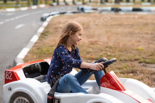 Preview: Happy little girl driving kart in park