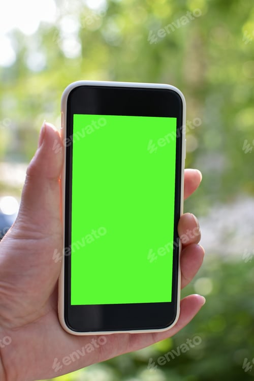 Preview: Women's hands hold a smartphone with an empty screen in nature. Chromakey. Place to copy.