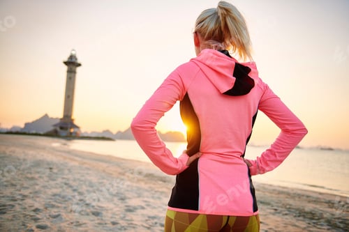 Preview: Rear view of sporty woman on the beach
