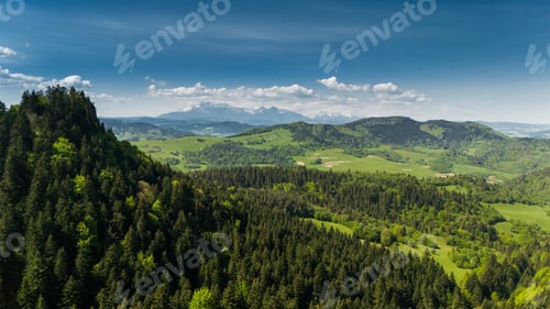 Preview: Aerial drone view over green hills of Pieniny National Park and snowy Tatra Mountains