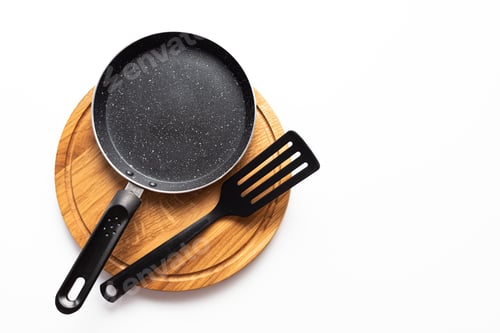 Preview: Top view frying pan and plastic spatula on white background