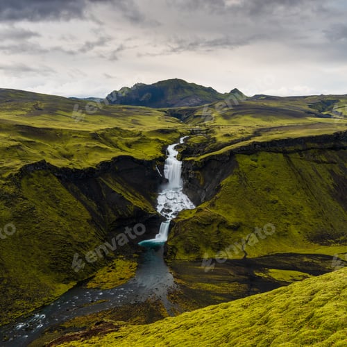 Preview: High angle shot of waterfalls in Highlands region of Iceland with a cloudy gray sky