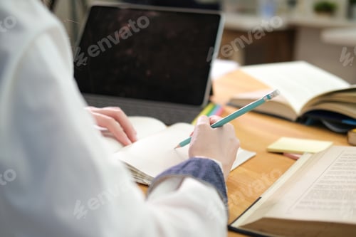 Preview: Young collage student using computer and digital tablet studying online.