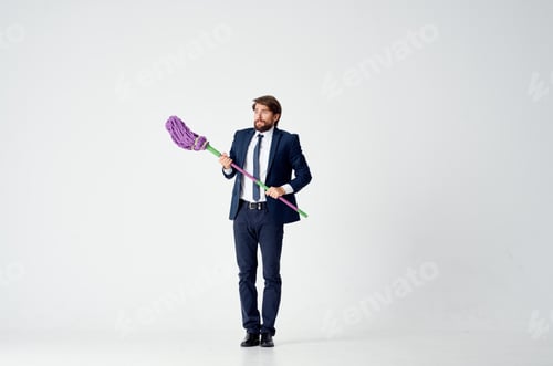 Preview: business man in a suit with a mop in his hands cleaning service