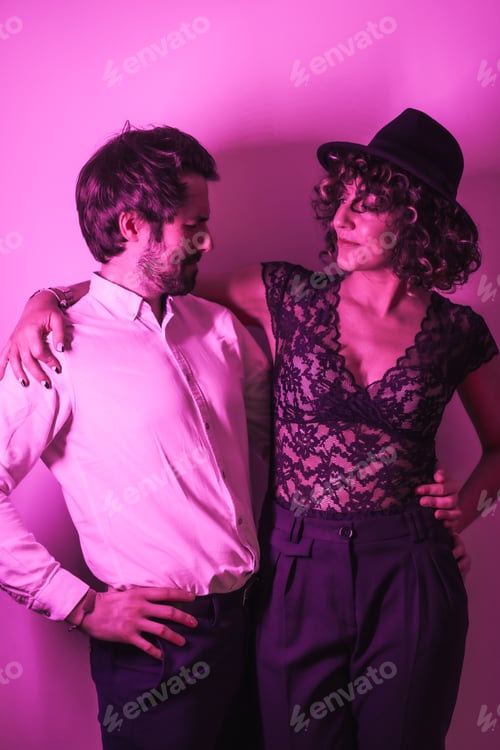 Preview: Studio lifestyle, a young Caucasian couple dancing, with neon pink light