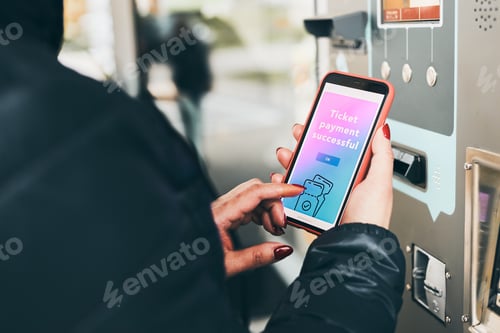 Preview: Woman buying ticket at ticket machine paying using mobile payment app on smartphone. Buy bus ticket