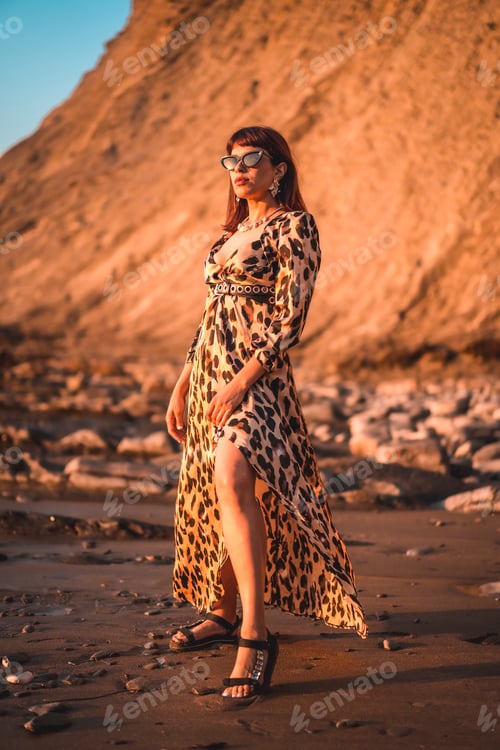 Preview: Summer lifestyle on a beach next to rocks of a young brunette Caucasian woman