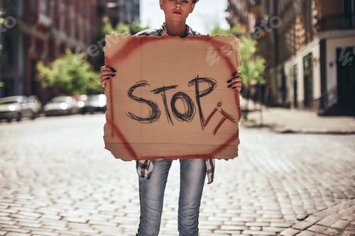 Preview: Stop violence. Cropped image of young female holding a signboard with word stop it while standing on