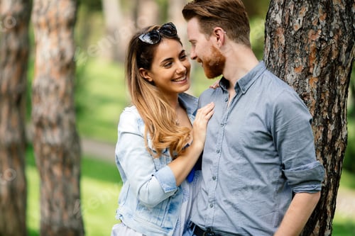 Romantic Young Couple Embracing near a Tree
